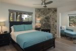 The second master suite has a queen bed and a rock wall ornamental fireplace